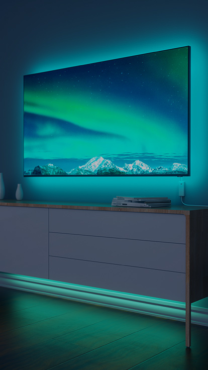 リビングのTVの後ろのNanoleaf Essentials Lightstripの画像です。 色が変わるライトストリップは、バックライトとRGBの光を放ちます。